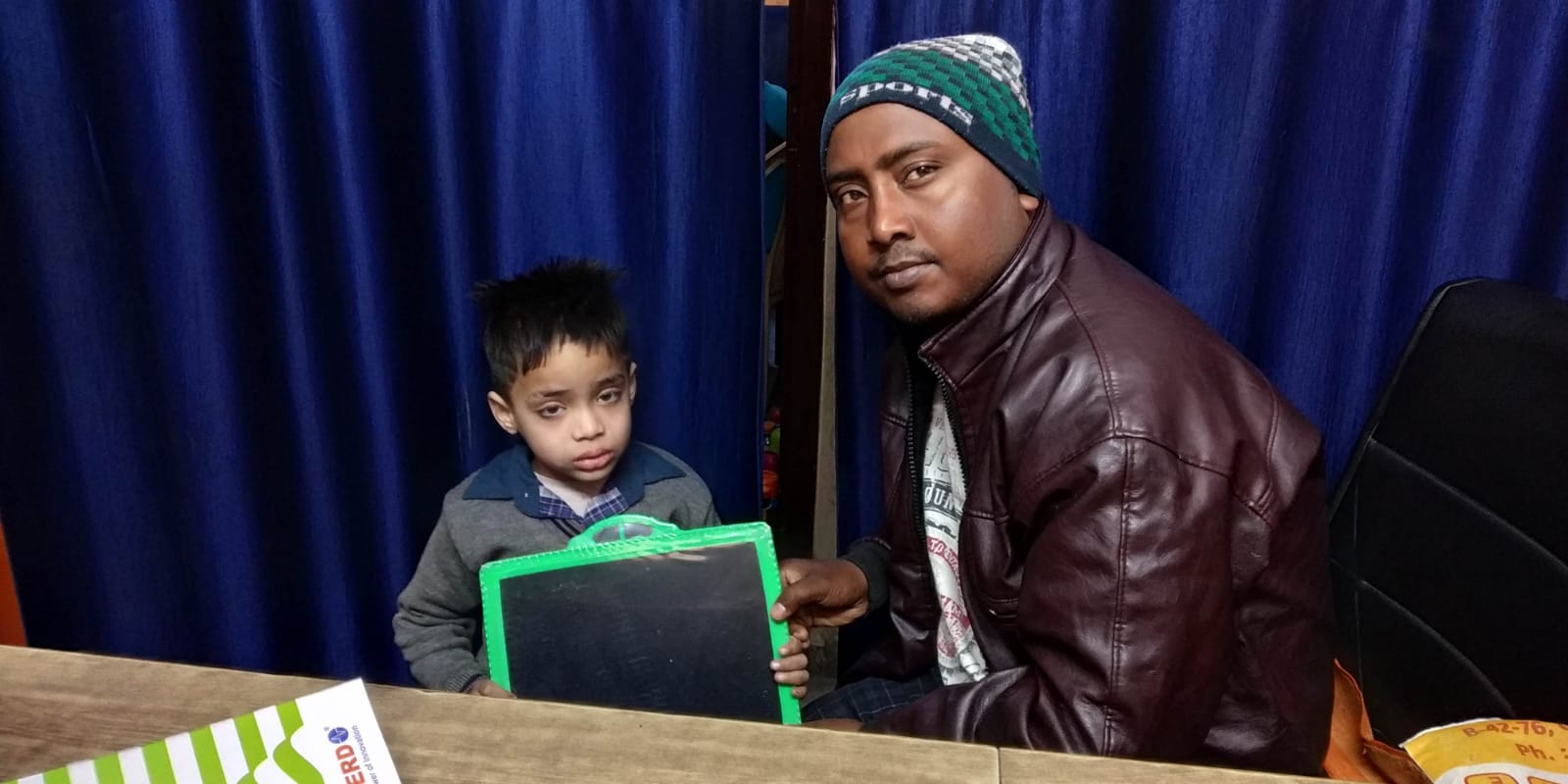 Teacher guiding young student with writing slate